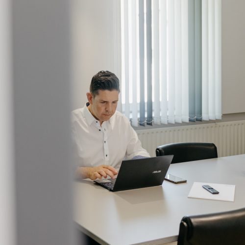 Stefan Schuler arbeitet in einem Besprechungsraum an seinem Laptop.